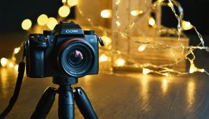 A camera on a tripod with twinkling string lights in the blurred background, capturing the enchanting essence of night photography at home.